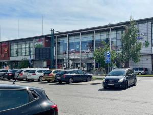 un estacionamiento con autos estacionados frente a un edificio en Utopia 1BR and sauna, en Tornio