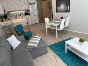 a living room with a couch and a table and a kitchen at Utopia 1BR and sauna in Tornio