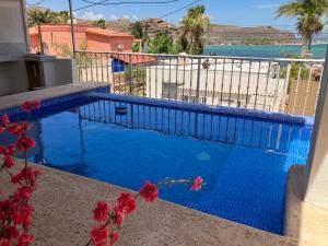 a blue swimming pool with a view of the ocean at Vista al mar y alberca privada en Sector Bahía in San Carlos