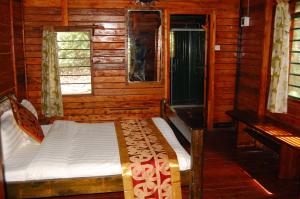 a bedroom with a bed in a log cabin at Snow Heights Lodges in Kasese