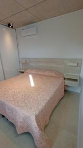 a small bedroom with a bed with a pink bedspread at Nereida in Mar Azul