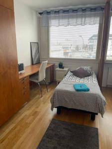 1 dormitorio con cama, escritorio y ventana en Luxury 2-3BR Tornio city Apparment, en Tornio