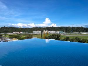 una gran piscina azul con vistas a un campo en Paradise Perch Tanjung Aru Inifnity Pool 2BR, en Kota Kinabalu