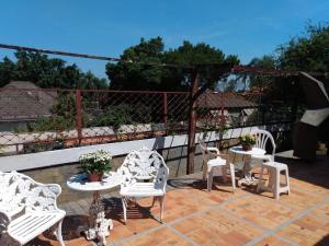 - un ensemble de chaises et de tables blanches sur une terrasse dans l'établissement Suítes encantadoras, à São Paulo