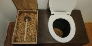 a bathroom with a toilet with a box of nuts at Marquis garden Eco-cottages in Tocdoc