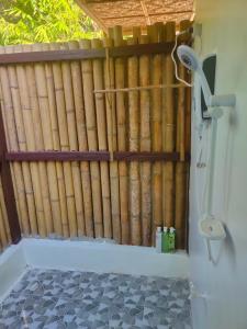 uma cerca de bambu na casa de banho com chuveiro em Marquis garden Eco-cottages em Tocdoc