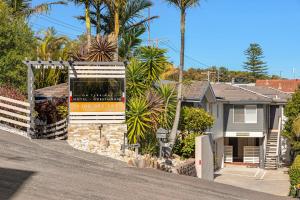 a house on a street with palm trees at Tiarri Terrigal in Terrigal