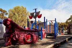 a playground with a slide in a park at Lorne Foreshore Caravan Park in Lorne