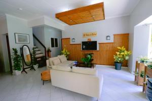a living room with white furniture and a flat screen tv at Villa de Babat in Basco