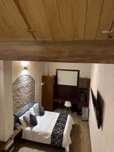 Dormitorio con cama, escritorio y TV en Hotel Del Valle, en Tecozautla