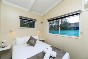 1 dormitorio con 2 camas y ventana en Reflections Coffs Harbour - Holiday Park, en Coffs Harbour
