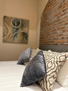una camera da letto con un muro di mattoni e un letto con cuscini di Hotel Del Valle a Tecozautla