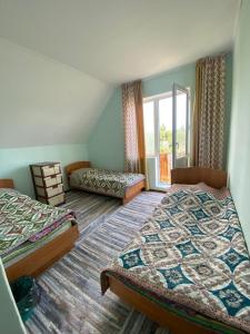 a bedroom with two beds and a window at Guest House Regina in Bulan Sogottuu