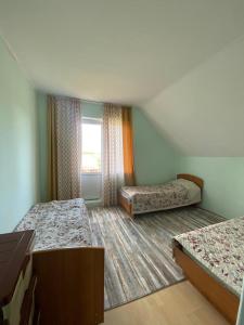 Bulan SogottuuにあるGuest House Reginaのベッド2台と窓が備わる客室です。