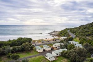 - une vue aérienne sur une plage avec des maisons et une route dans l'établissement Kennett River Family Caravan Park, à Wye River