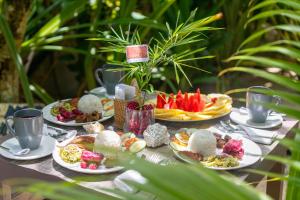 a table with plates of food on top at Coracasa bed and breakfast in General Luna