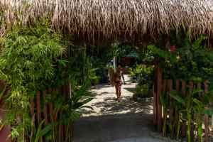 a person walking through a gate with a straw roof at Coracasa bed and breakfast in General Luna