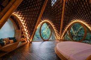 a room in a tree house with three circular windows at Suenyo Eco Retreat in Tabanan