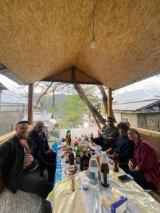 grupa ludzi siedzących przy stole z jedzeniem w obiekcie BBQ House w mieście Dilidżan