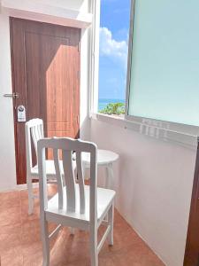 a room with two chairs and a table and a window at 88 House Patong in Patong Beach