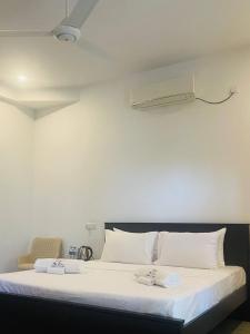 1 dormitorio con 1 cama blanca grande con almohadas blancas en The Glen Kandy en Kandy