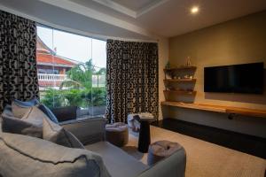 a living room with a couch and a large window at Villa U - Beachfront Haven in Lipa Noi