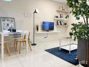 a living room with a table and a tv at Mercu Summer Suite Kuala Lumpur in Kuala Lumpur