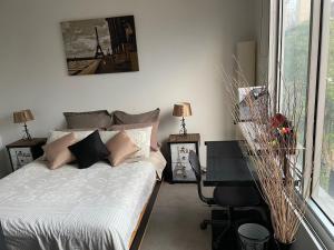1 dormitorio con cama y escritorio junto a una ventana en Radiance - Chic Fitzroy Street Apartment, en Melbourne