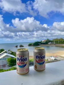 two cans of orion life drink sitting on a table overlooking the ocean at Aqua shallows in Onna