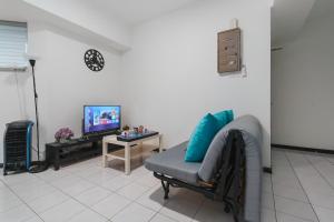 a living room with a couch and a tv at Plaza Berjaya Apt Bukit Bintang With 3 Bedroom in Kuala Lumpur