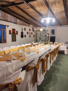 a long banquet hall with white tables and chairs at Finca San Alejandro in Cotacachi