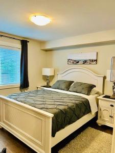 Un dormitorio con una cama grande y una ventana en A Cozy Family get away suite in South Nanaimo en Nanaimo