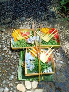 three trays of different types of food with sticks at Kasapa Inn in Ubud