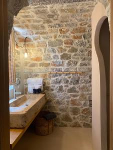 Baño de piedra con lavabo y pared de piedra en Inspiro Retreat Mani, 