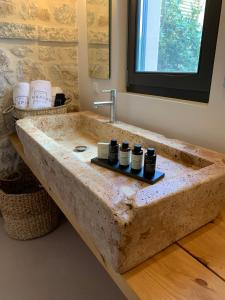 Baño con lavabo de piedra grande y espejo en Inspiro Retreat Mani, 