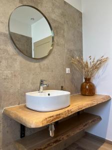 een badkamer met een witte wastafel en een spiegel bij A PIAZZOLA in Petreto-Bicchisano