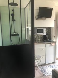 une porte menant à une cuisine équipée d'un four micro-ondes et d'un bureau. dans l'établissement STUDIO 11m2, à Magny-Cours