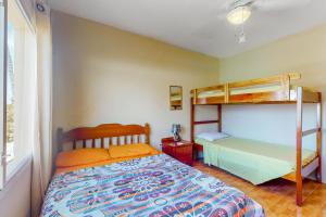 1 dormitorio con 1 cama y literas en De Real Macaw, en Caye Caulker
