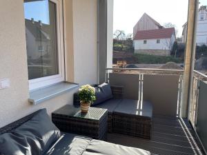欣費爾德的住宿－Wohnung für Berufstätige，阳台配有沙发、桌子和窗户。