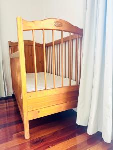 a wooden crib in a room with a curtain at Ocean View 3 bedroom entire house central of Caloundra in Caloundra West