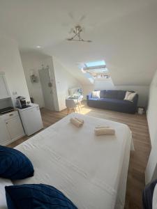 a bedroom with a white bed and a blue couch at Fior di Loto Suite - Lingotto in Turin