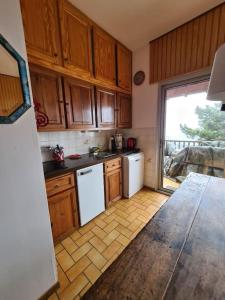 a kitchen with wooden cabinets and a white refrigerator at Chalet Puyvalador station vue panoramique montagne in Puyvalador