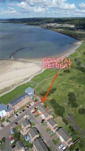 an aerial view of a beach with a red arrow pointing to a coastal retreat at Coastal Retreat in Carmarthenshire in Llanelli