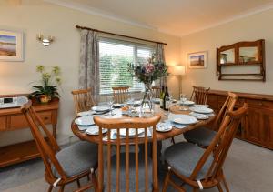 a dining room with a wooden table and chairs at Sunnydale in Llanbedrog