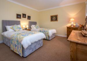 a hotel room with two beds and a desk at Sunnydale in Llanbedrog