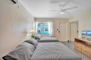 a bedroom with two beds and a flat screen tv at Hollywood Broadwalk Holiday Retreat Dania Beach in Hollywood