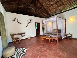 Zimmer mit einem Bett und einem Schreibtisch. in der Unterkunft NatShi Lodge in Ambaro