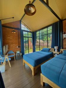 two beds in a room with blue sheets at The Maewin Coffee & Cottage Economy Twin Room in Ban Yang Huai Tong