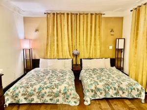 duas camas num quarto de hotel com cortinas amarelas em EWR AIRPORT Multilevel Guest House Room with 2-3 Beds em Newark