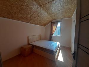 una piccola camera da letto con un letto e una finestra di Guest House Sevan a Sevan